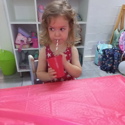 A child enjoying a drink at snack time